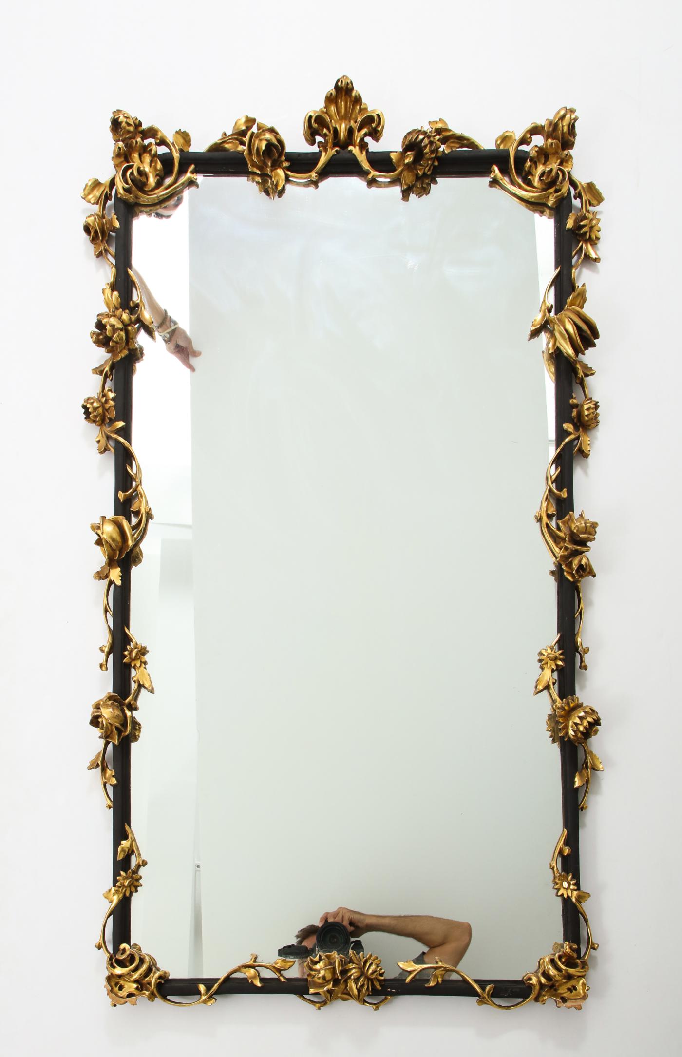 An Italian Rococo style giltwood and black painted wall mirror