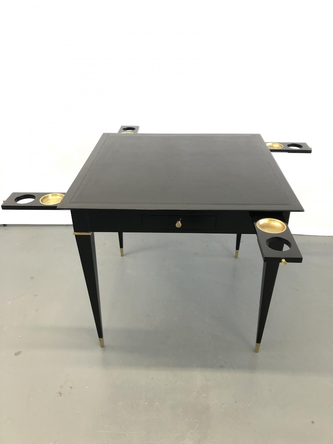 A game table, ebonized mahogany, bronze details and leather top.