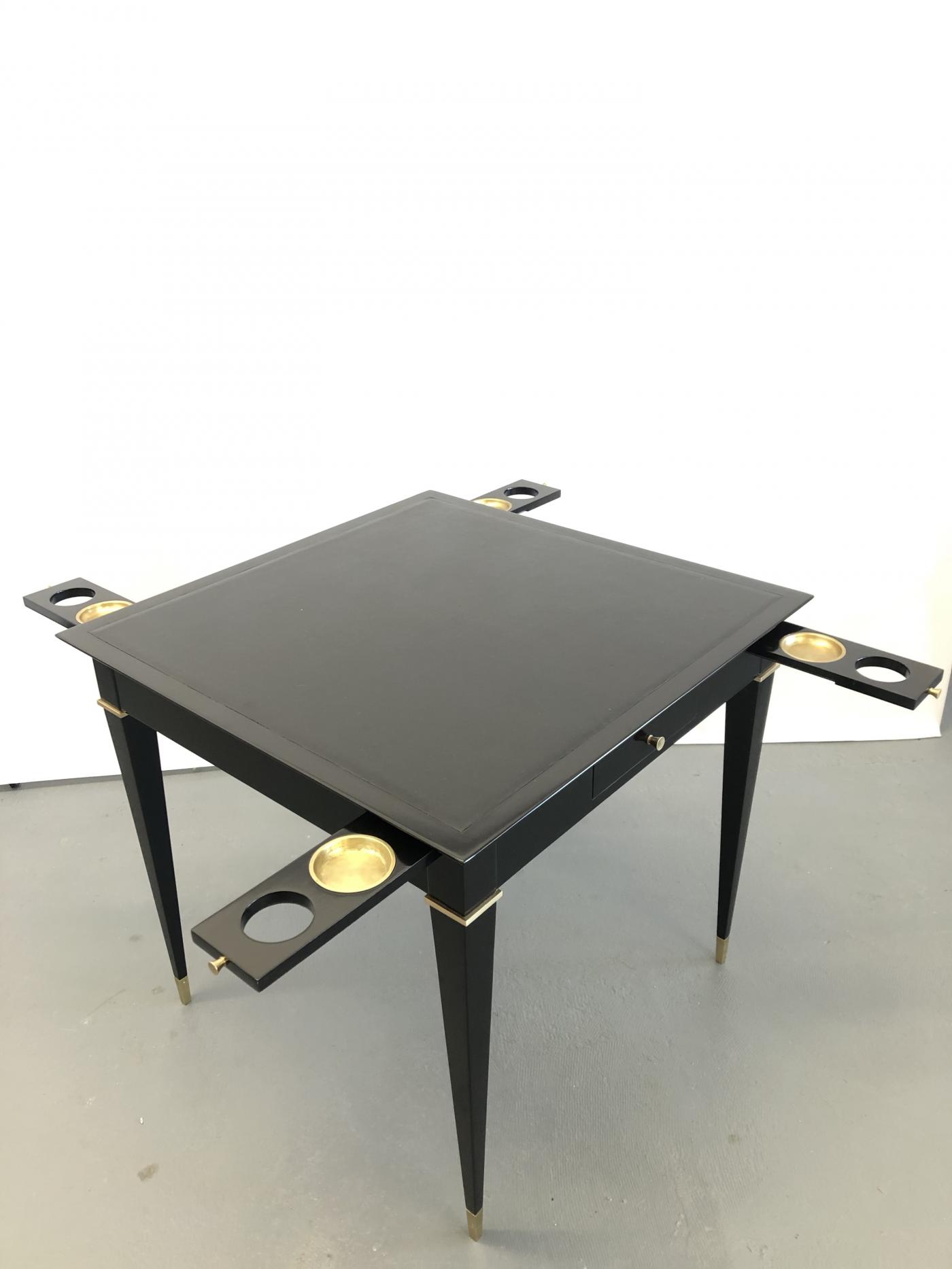A game table, ebonized mahogany, bronze details and leather top.